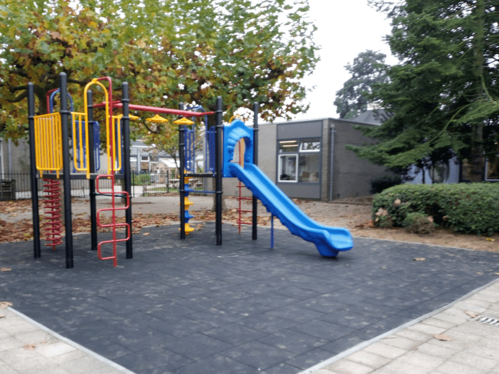 Klimtoestel met kunststof glijbaan op schoolplein van IKC Het Drieluik in Huissen