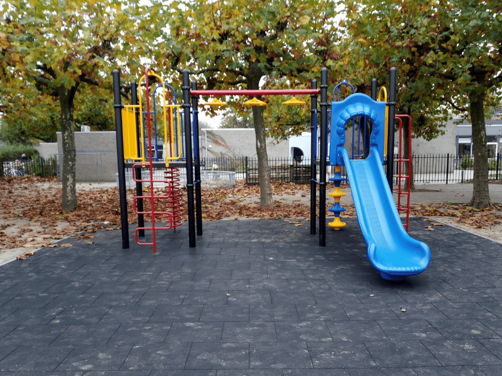 Klimtoestel met kunststof glijbaan op schoolplein van IKC Het Drieluik in Huissen